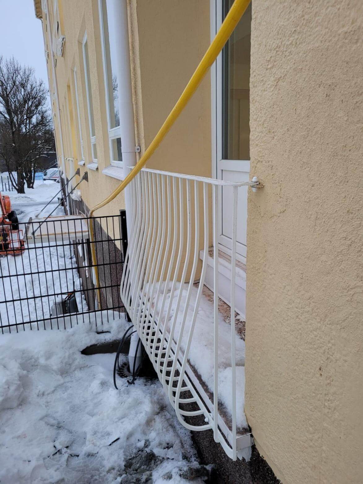 Valkoinen kaide keltaisessa talossa